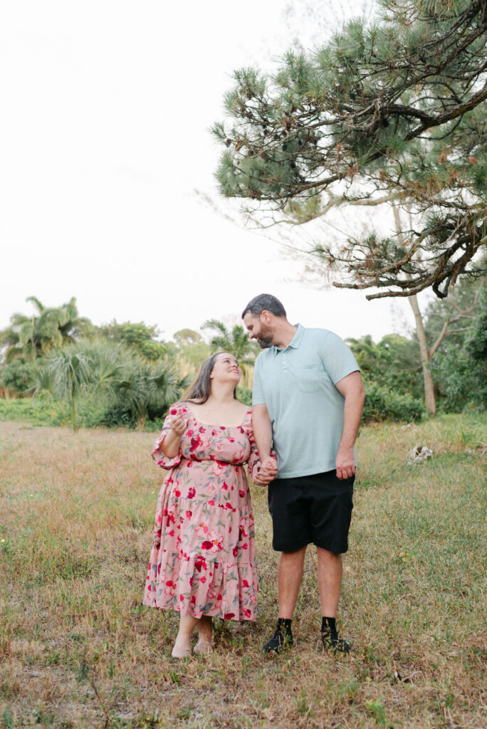Newly engaged couple looking at photographer with joyful expressions