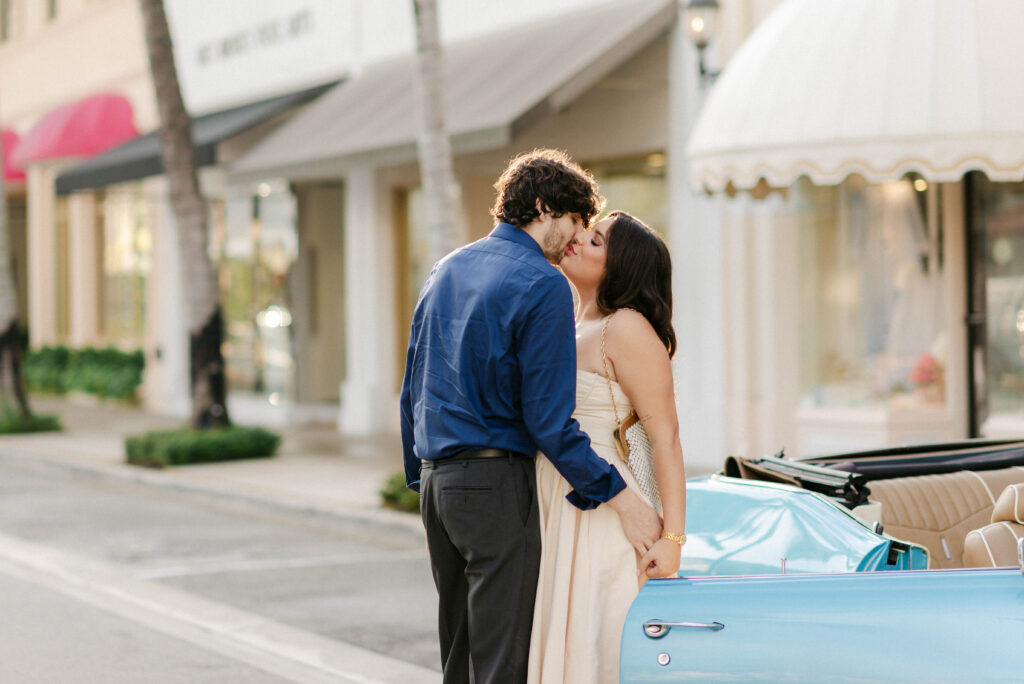 Romantic candid of couple kissing hand in hand down the avenue