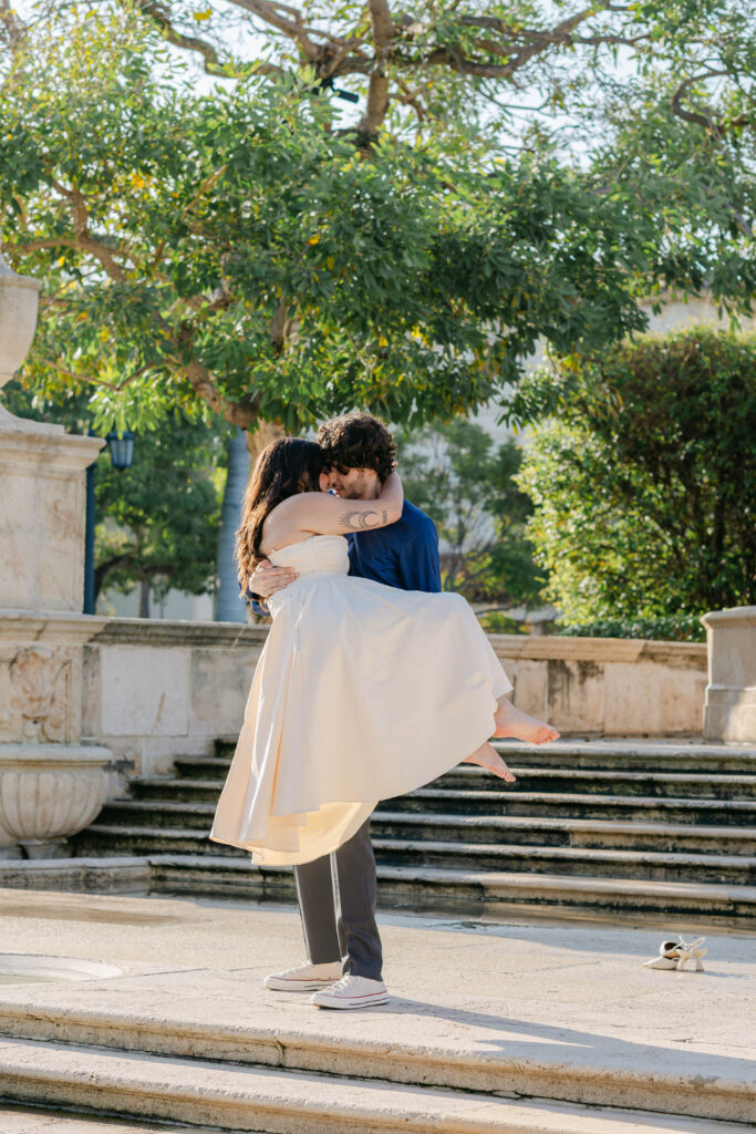 couple kisses on the steps at the palm beach memorial park