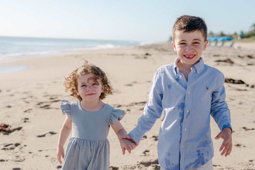 Siblings playing together during beach family session