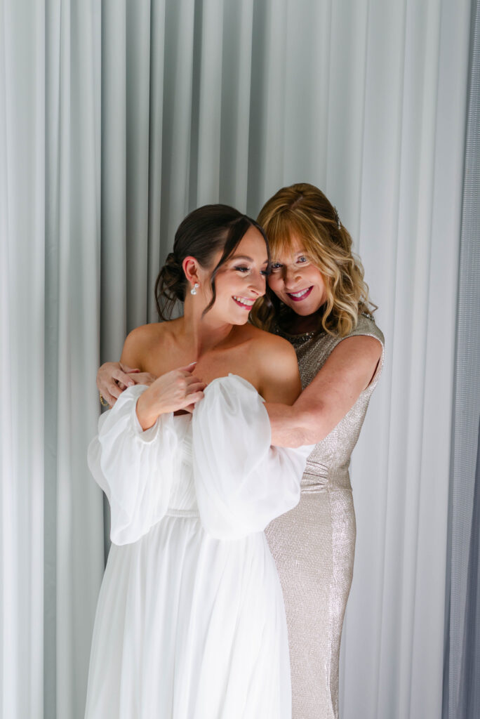 mother and daughter hugging after putting on the wedding dress