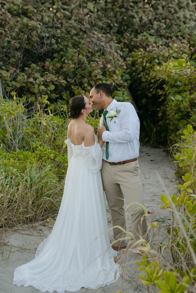 bride and groom going in for a kiss during sunset photos