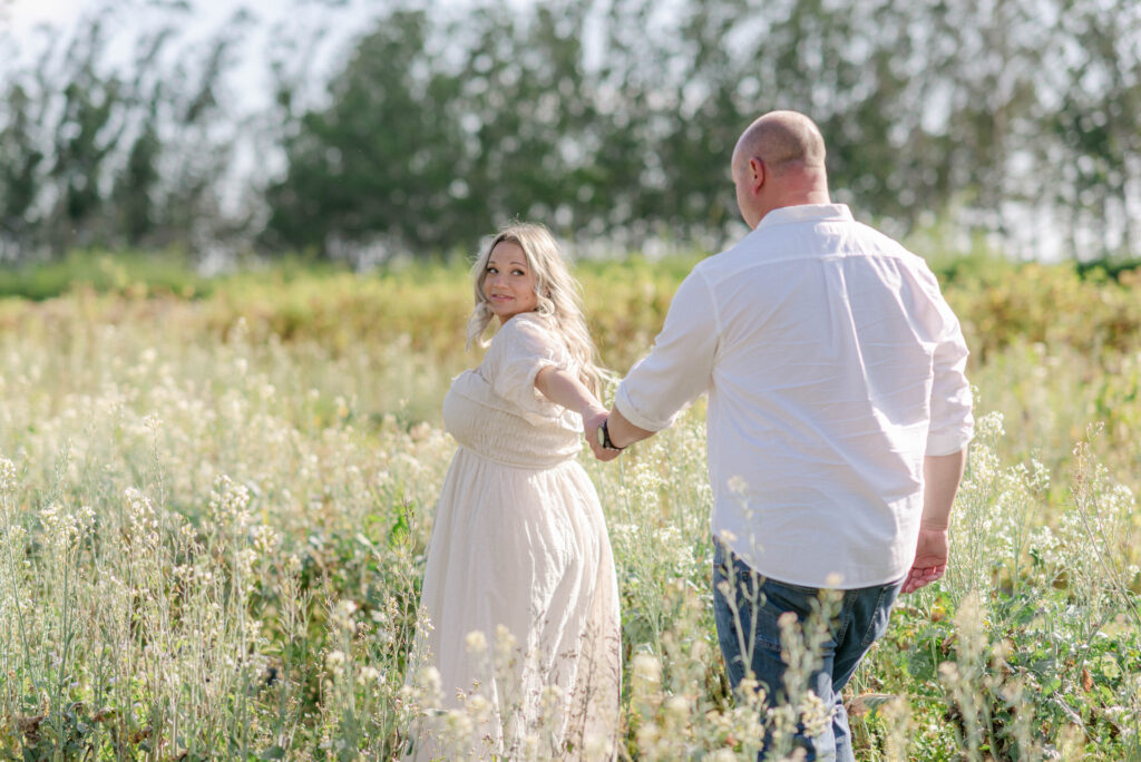 Pregnant mother standing in front of Kai-Kai Farm garden rows during summer photo session