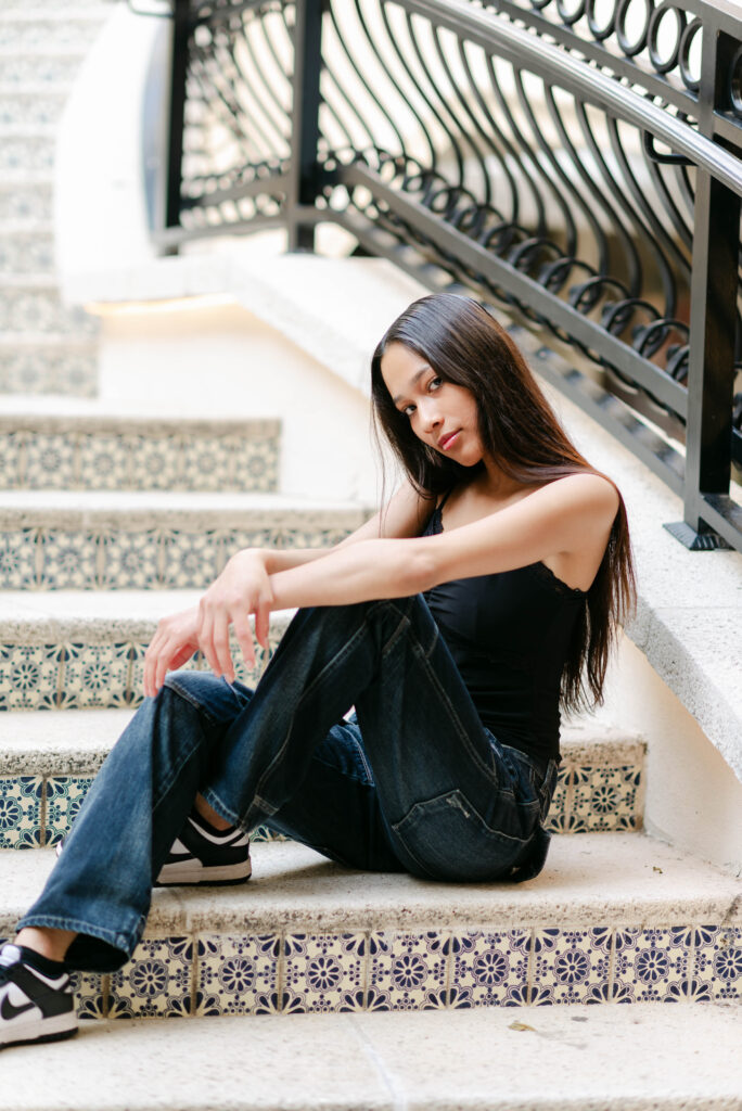 Model sitting against textured steps in natural light