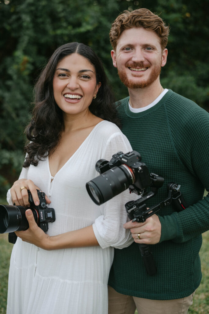 Amy and Kevin smiling together while holding cameras, Ocala wedding and family photographers capturing a joyful moment