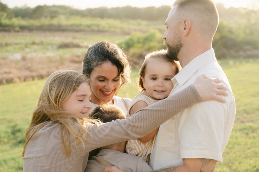 siblings laughing together during outdoor family photos