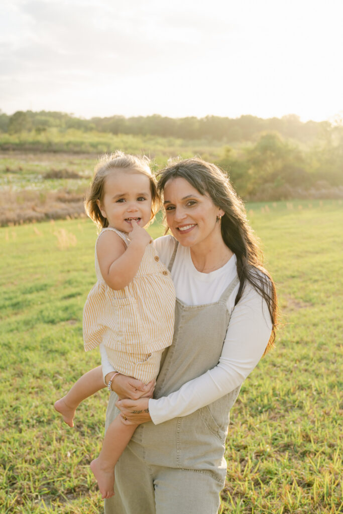 mom holding daughter during sunset family session