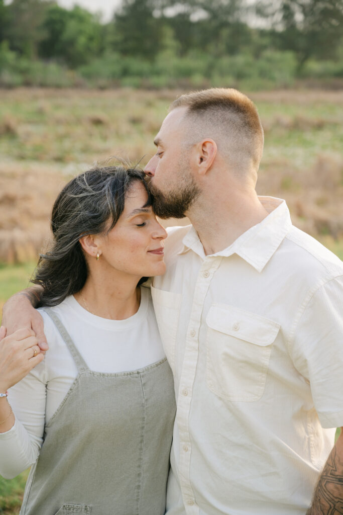 a tender forehead kiss between mom and dad during an ocala family shoot
