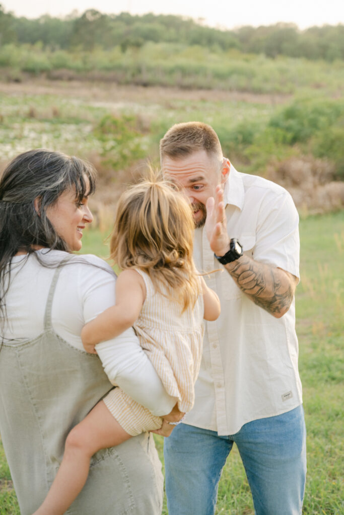 mom and dad interacting with baby girl during family photos