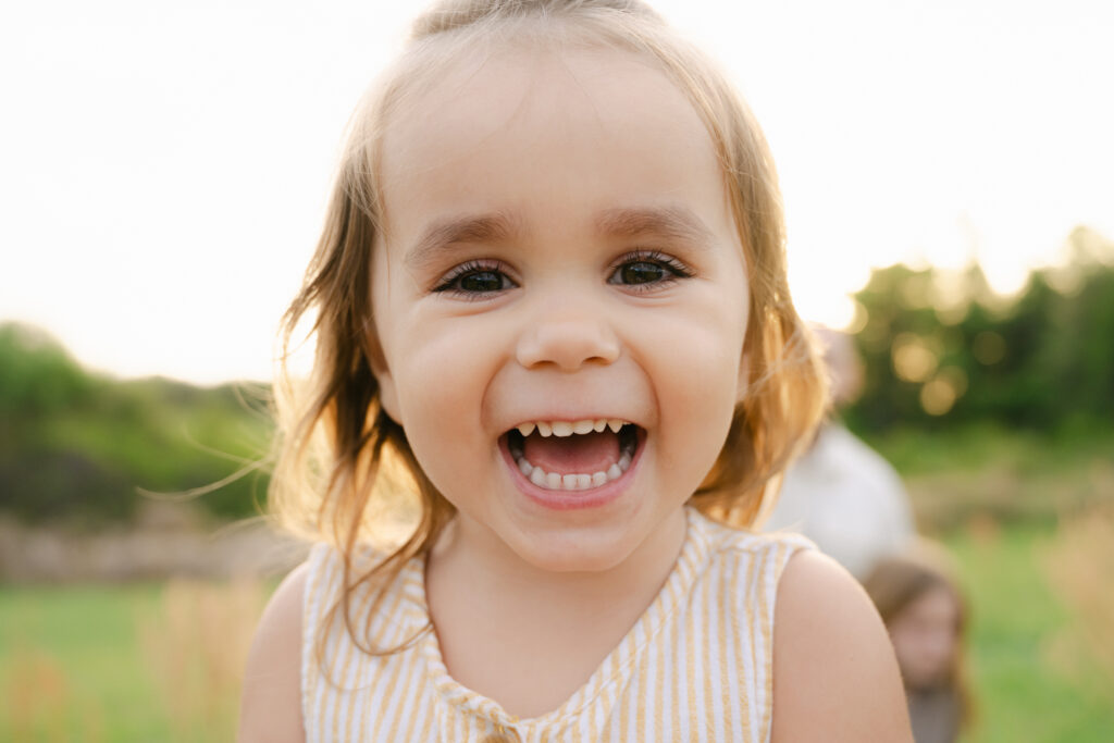 baby girl giving a big smile at sunset